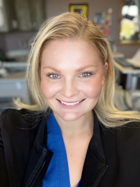 Smiling woman with blonde hair in a professional setting.